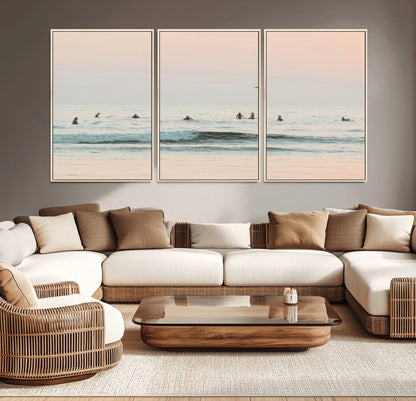 Dreamy photo of surfers waiting on soft pastel waves under a pink sunset sky, ideal for soft coastal minimalist or serene ocean-themed home decor.