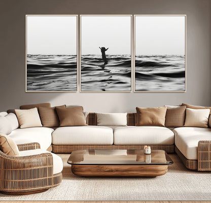 Black and white ocean with a hand making a surfer sign among dark waves, creating a dramatic and minimalist seascape with bold contrast.