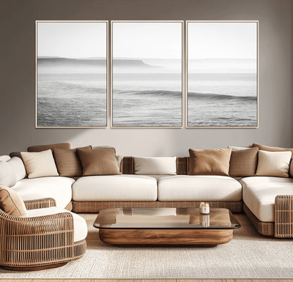 A black and white minimalist seascape featuring soft rolling waves and misty distant cliffs, creating a serene and timeless coastal atmosphere.