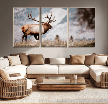 Majestic elk with large antlers standing in grass with snowy mountains in background, perfect for rustic cabin or lodge style decor.