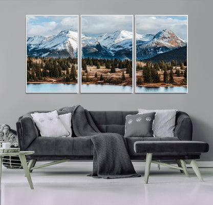 Framed canvas of snowy mountain peaks with pine forest and alpine lake, perfect for winter cabin or wilderness-inspired home decor.