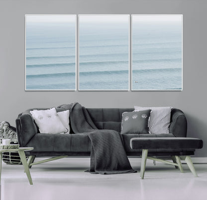 Framed canvas of repeating ocean waves with a distant solo surfer, ideal for minimalist ocean or calm coastal wall decor.