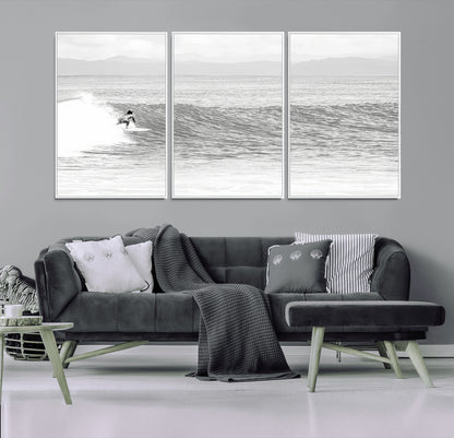 Monochrome photo of a surfer riding a wave with distant mountains, ideal for coastal motion or black and white surf-themed wall decor.