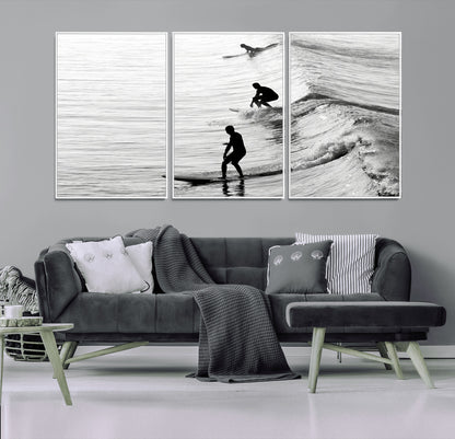 Black and white photo of surfers riding waves in a moody, high-contrast scene, ideal for modern coastal or surf-inspired home decor.