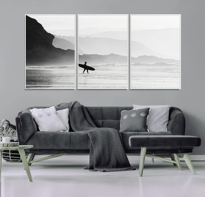 A lone surfer walking along a misty beach with cliffs in the background, carrying their board, capturing a serene and minimal ocean moment.