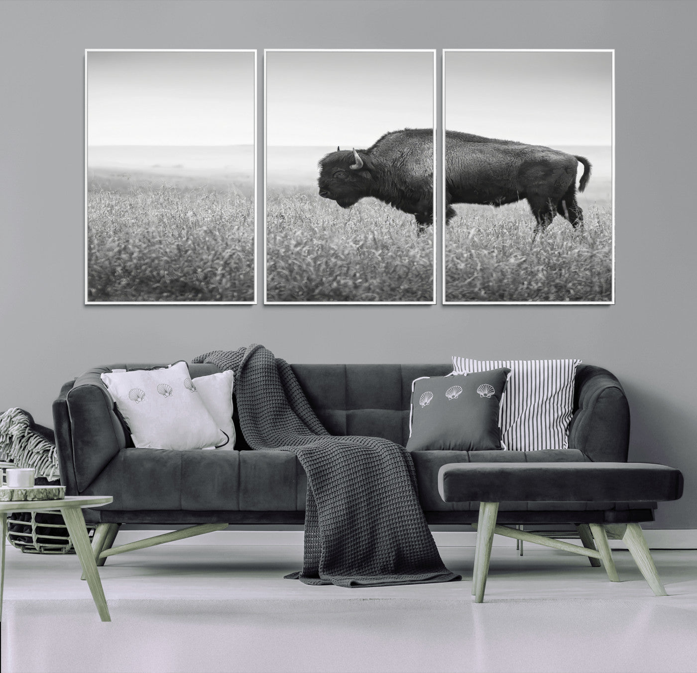 A black and white photograph of a majestic bison standing in a vast grassy prairie, evoking a sense of wilderness and strength.