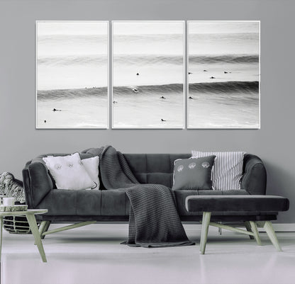 A monochrome photograph of swimmers gliding through gentle ocean waves, evoking a sense of calm and movement.