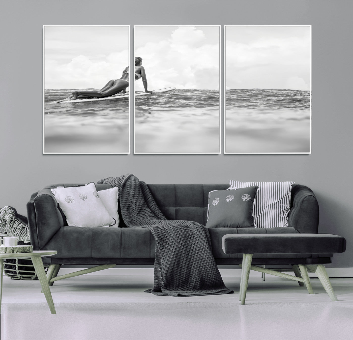 A black and white ocean scene featuring a surfer girl waiting on her board, gazing at the horizon, capturing a tranquil and adventurous coastal moment.