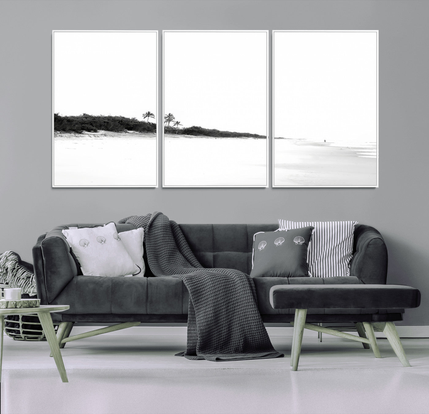 A black and white minimalist coastal scene with a vast open beach, distant palm trees, and a lone figure walking along the shoreline, evoking serenity and solitude.