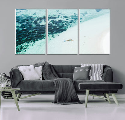 Canvas featuring an aerial view of a swimmer in shallow turquoise waters with coral patterns, ideal for tropical coastal home decor.
