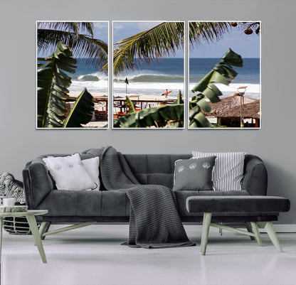 Canvas wall art of a tropical surf scene framed by palm trees, with a surfer on the shore and waves rolling in, ideal for beach-themed decor.