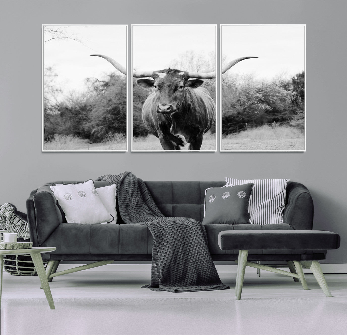Black and white photo of a longhorn cow in a field, perfect for rustic farmhouse or western-themed interior wall decoration.