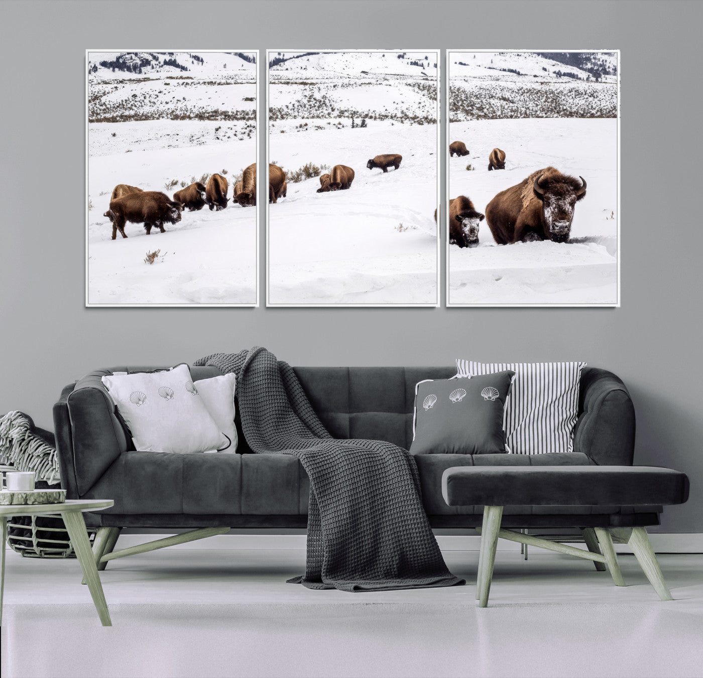 A herd of bison walking through deep snow in a mountain valley, perfect for rustic, cabin or western-themed wall decor.