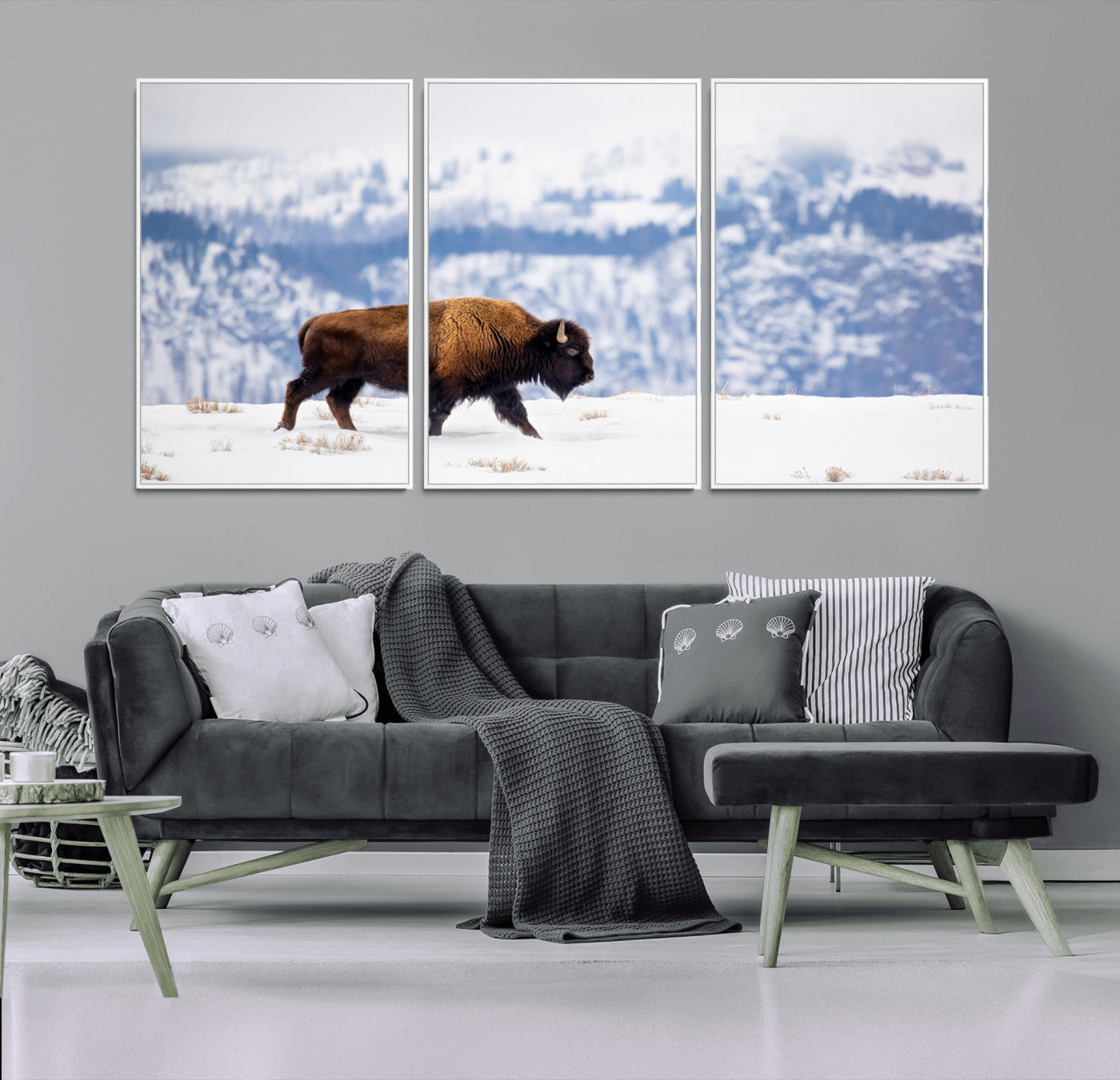 A lone bison walks across snowy ground with blue-toned mountain range behind, ideal for rustic or western farmhouse interiors.