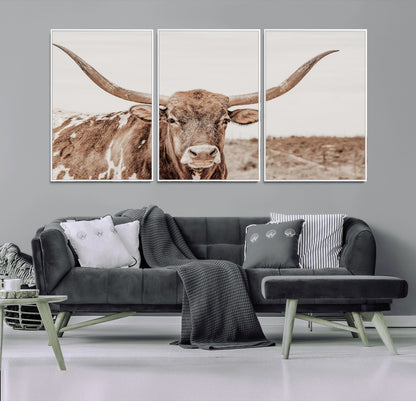 A longhorn cow in soft beige desert tones, standing calmly in open land, perfect for neutral western or rustic farmhouse interiors.