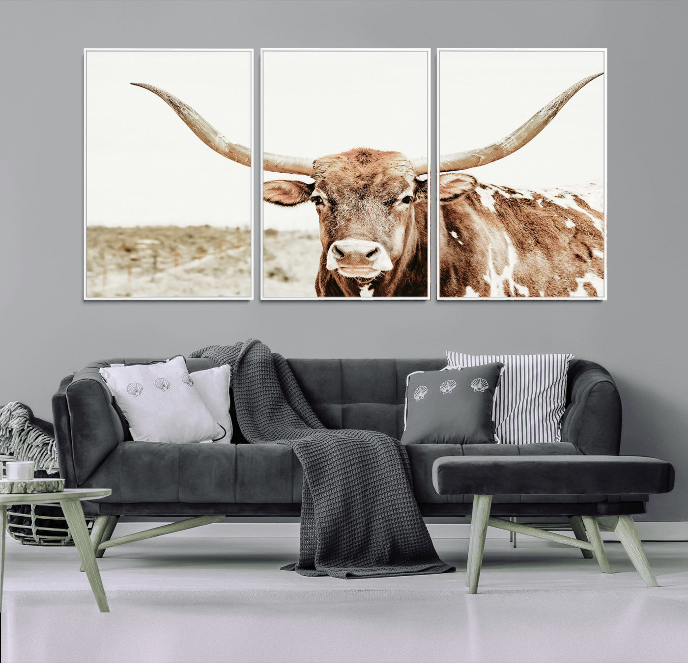 A Texas longhorn bull with wide horns, standing in a dry field under soft light, ideal for rustic farmhouse or western-themed interiors.