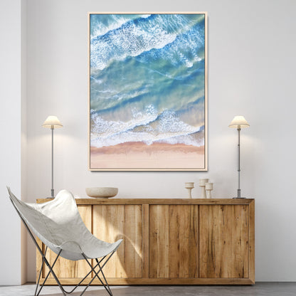 Aerial photo of soft blue waves meeting sandy shore, perfect for modern coastal or beach-themed decor with a light and tranquil aesthetic.