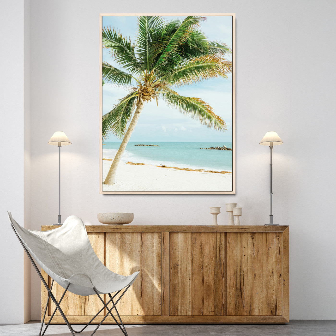 A tall palm tree leaning over a white sandy beach with turquoise ocean waves, creating a peaceful and tropical coastal scene.