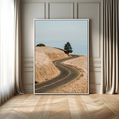 Earth-toned photograph of a winding road through golden hills, ideal for neutral or rustic-themed decor with a calming travel vibe.