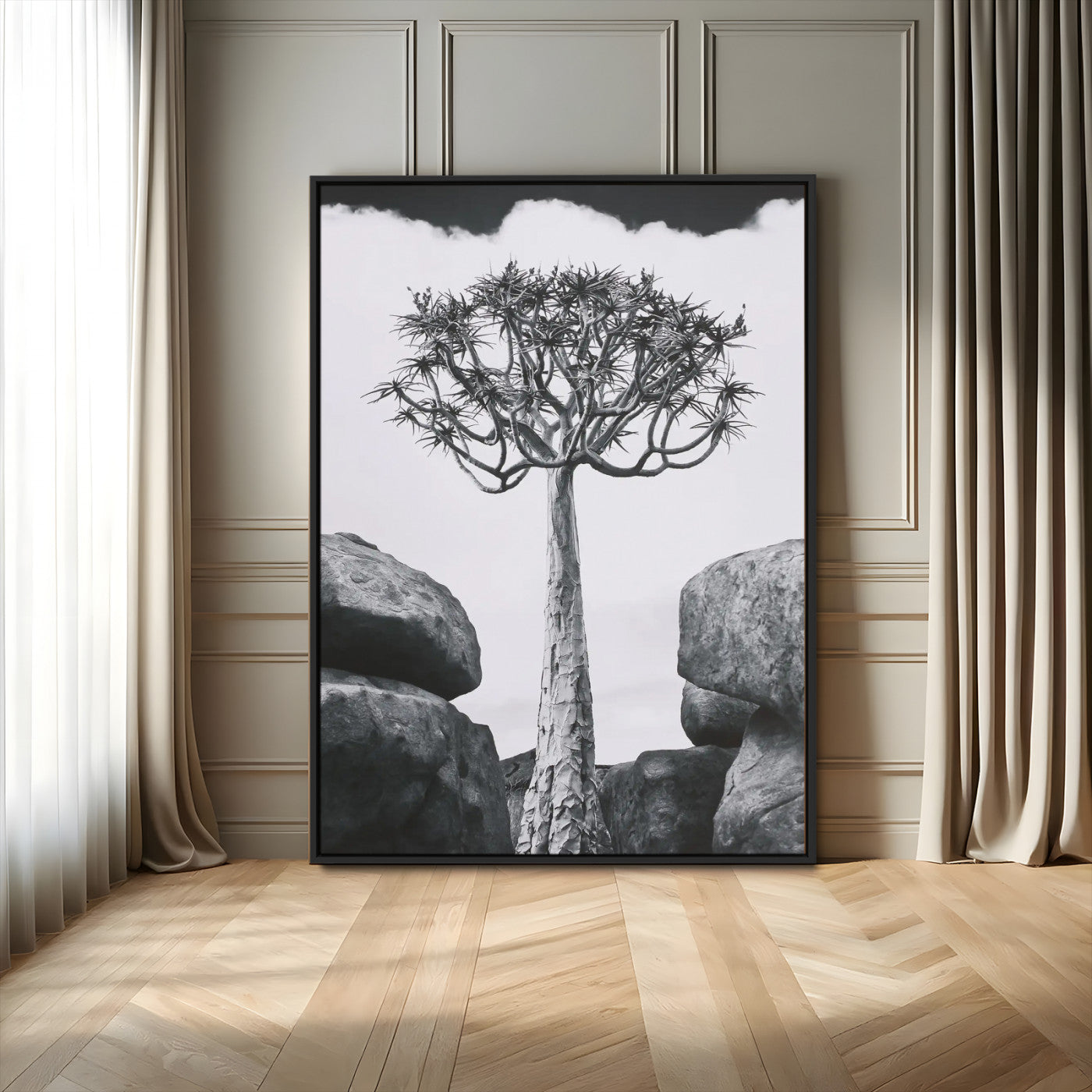Tall desert tree in black and white, standing between large rocks, perfect for bold and minimalist nature-themed interior spaces.
