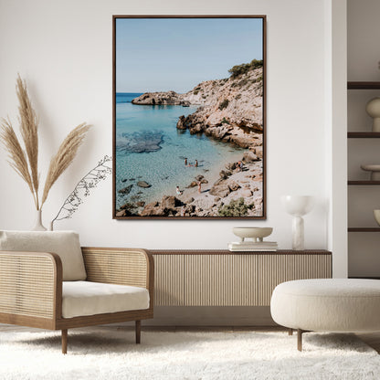 A vibrant coastal photo of a rocky Mediterranean cove with turquoise waters and beachgoers, ideal for boho coastal or summer-inspired interiors.