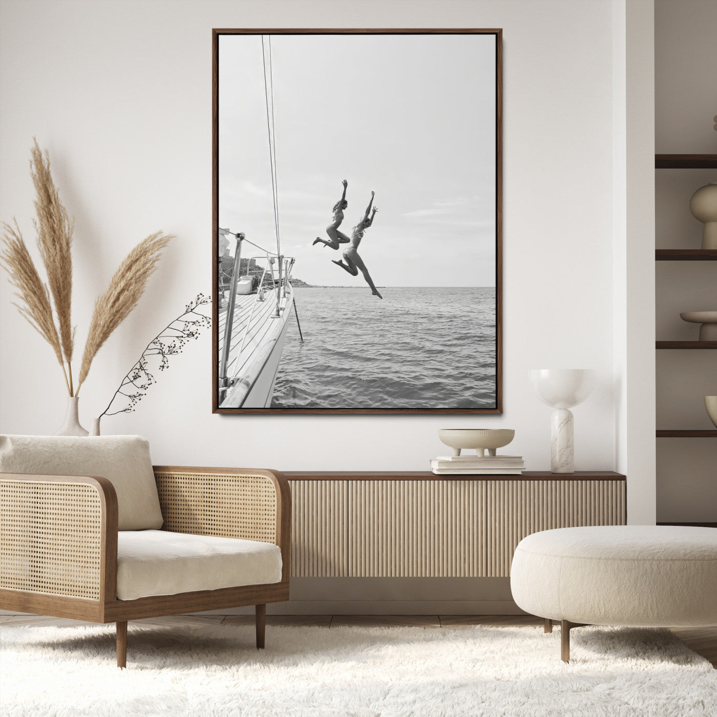 Black and white canvas wall art of two women joyfully jumping off a yacht into the sea, ideal for minimalist coastal or nautical-themed spaces.
