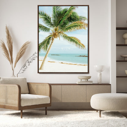 A tall palm tree leaning over a white sandy beach with turquoise ocean waves, creating a peaceful and tropical coastal scene.