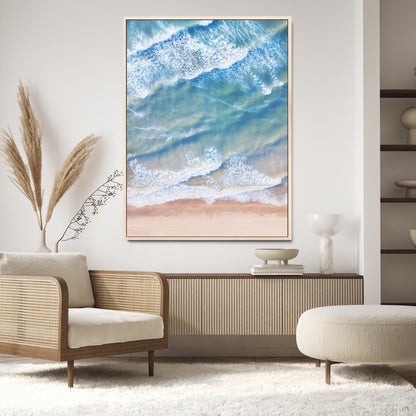 Aerial photo of soft blue waves meeting sandy shore, perfect for modern coastal or beach-themed decor with a light and tranquil aesthetic.