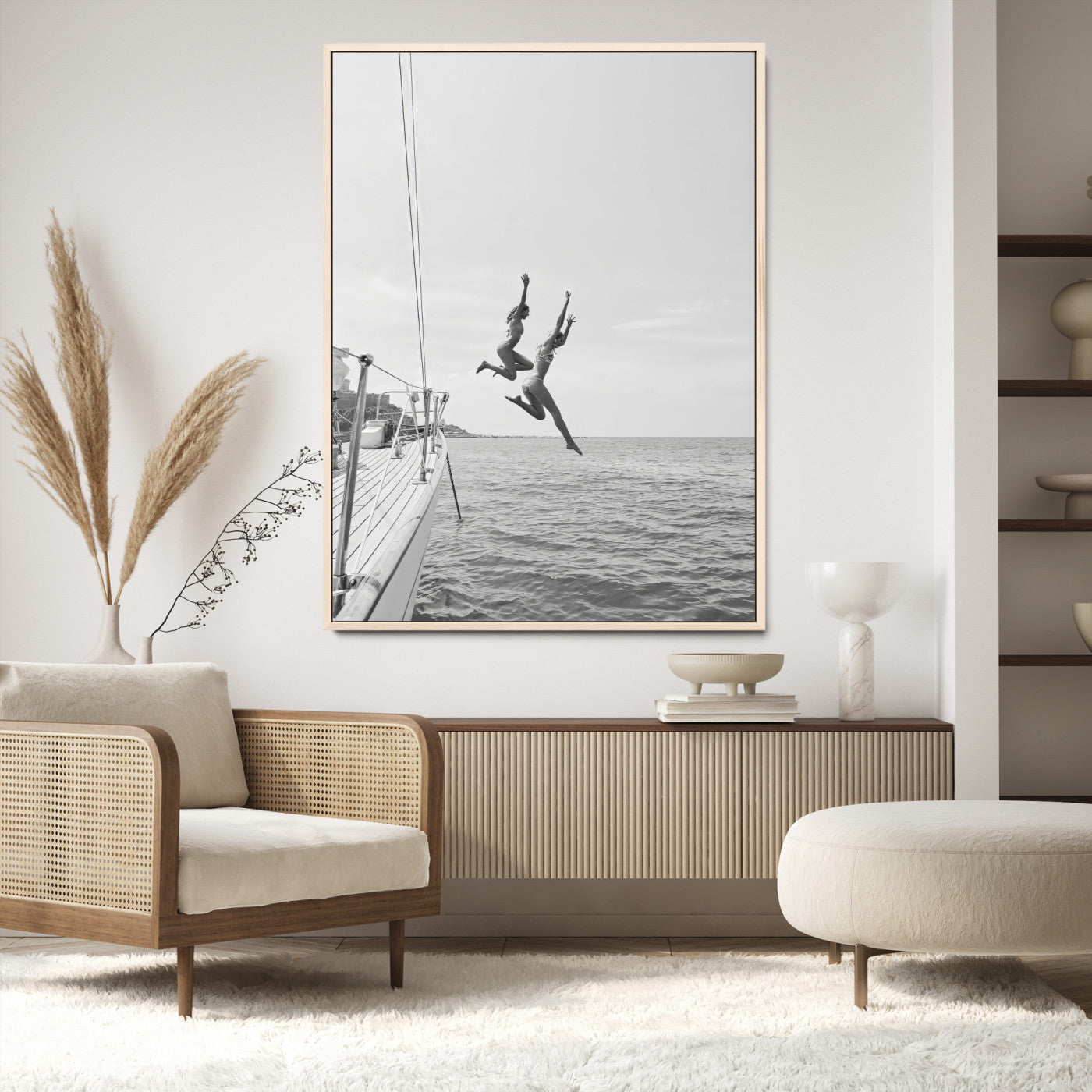 Black and white canvas wall art of two women joyfully jumping off a yacht into the sea, ideal for minimalist coastal or nautical-themed spaces.