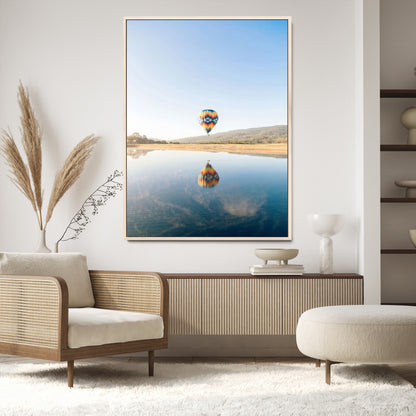 Canvas of a hot air balloon floating above a calm lake with soft reflections and vibrant sky, ideal for modern minimalist or adventure-themed home decor.