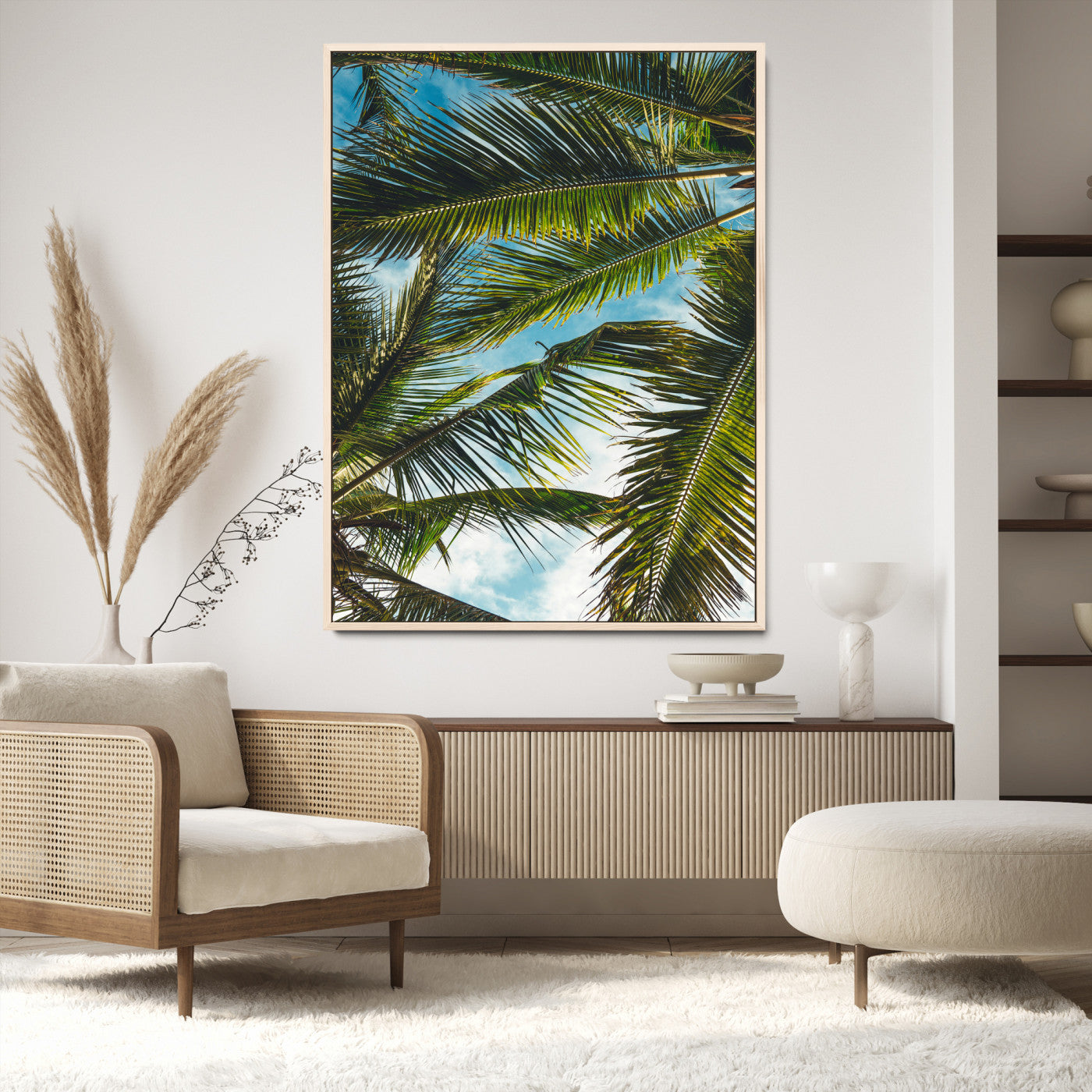 Looking up at lush green palm leaves against a bright blue sky, creating a tropical and relaxing coastal aesthetic.