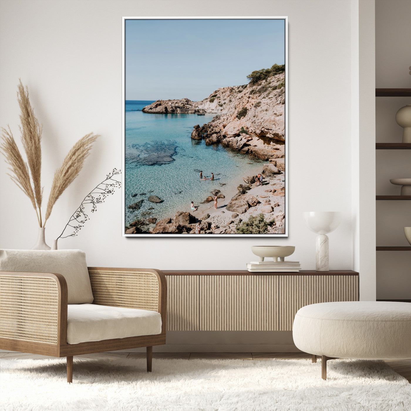 A vibrant coastal photo of a rocky Mediterranean cove with turquoise waters and beachgoers, ideal for boho coastal or summer-inspired interiors.