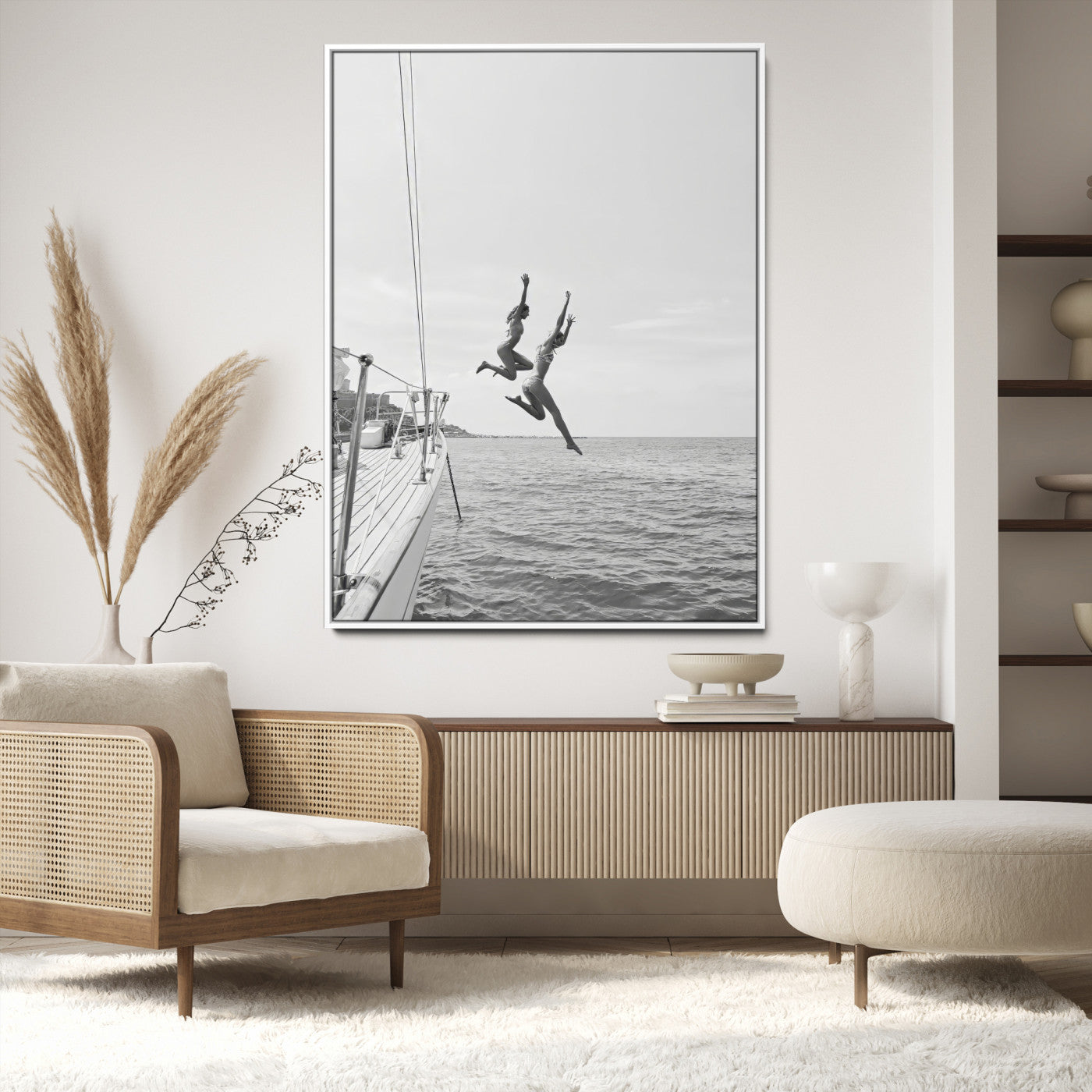 Black and white canvas wall art of two women joyfully jumping off a yacht into the sea, ideal for minimalist coastal or nautical-themed spaces.