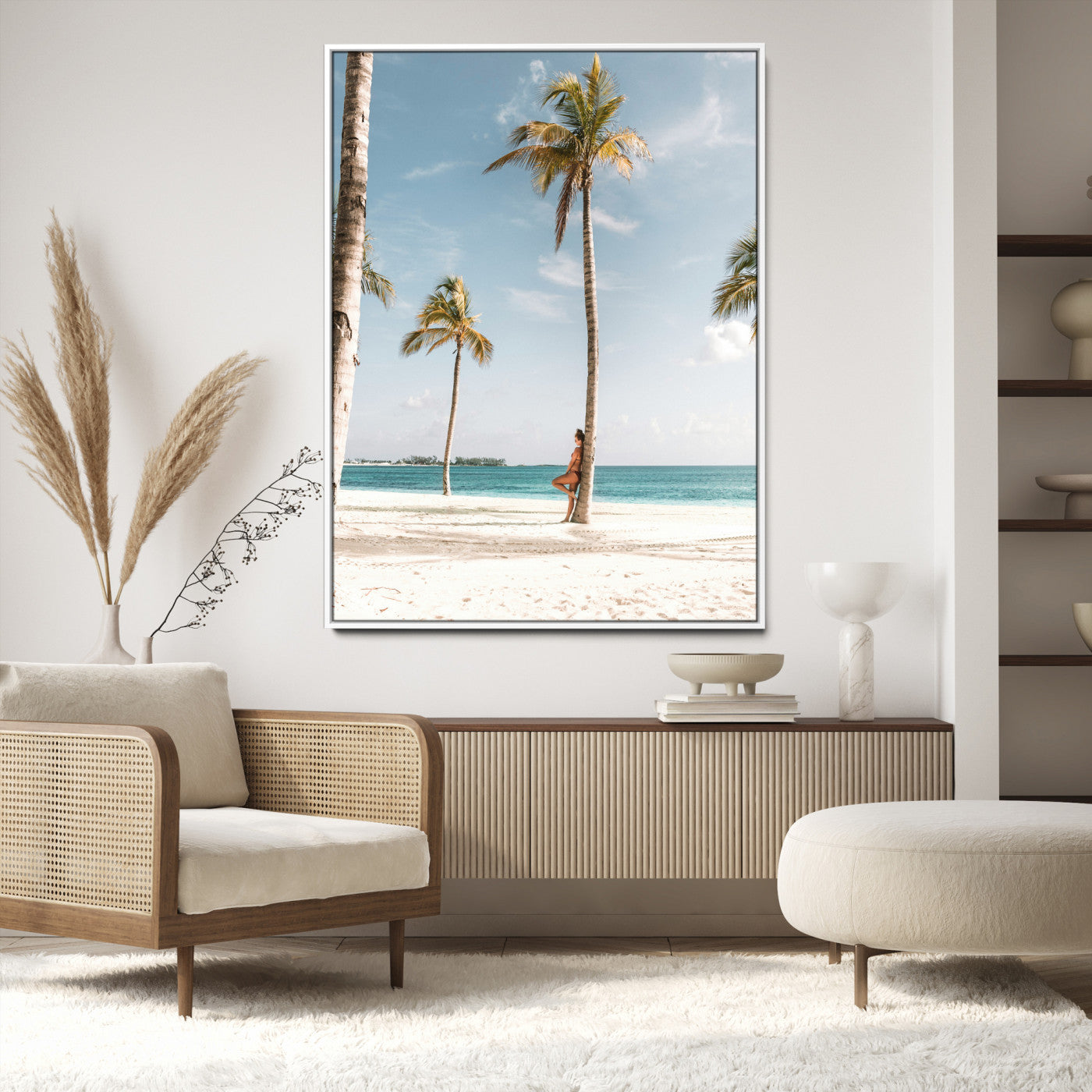 Person leaning on a palm tree at a tropical beach with white sand and turquoise water, perfect for coastal or beach-themed home decor.