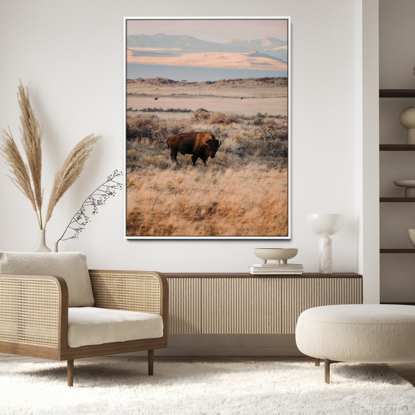 A solitary bison standing in golden prairie grass with distant mountains and soft sunset light, ideal for rustic, lodge, and western decor.