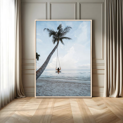 Wall art of a girl on a swing hanging from a palm tree over calm ocean waters, perfect for tropical or minimalist coastal decor.