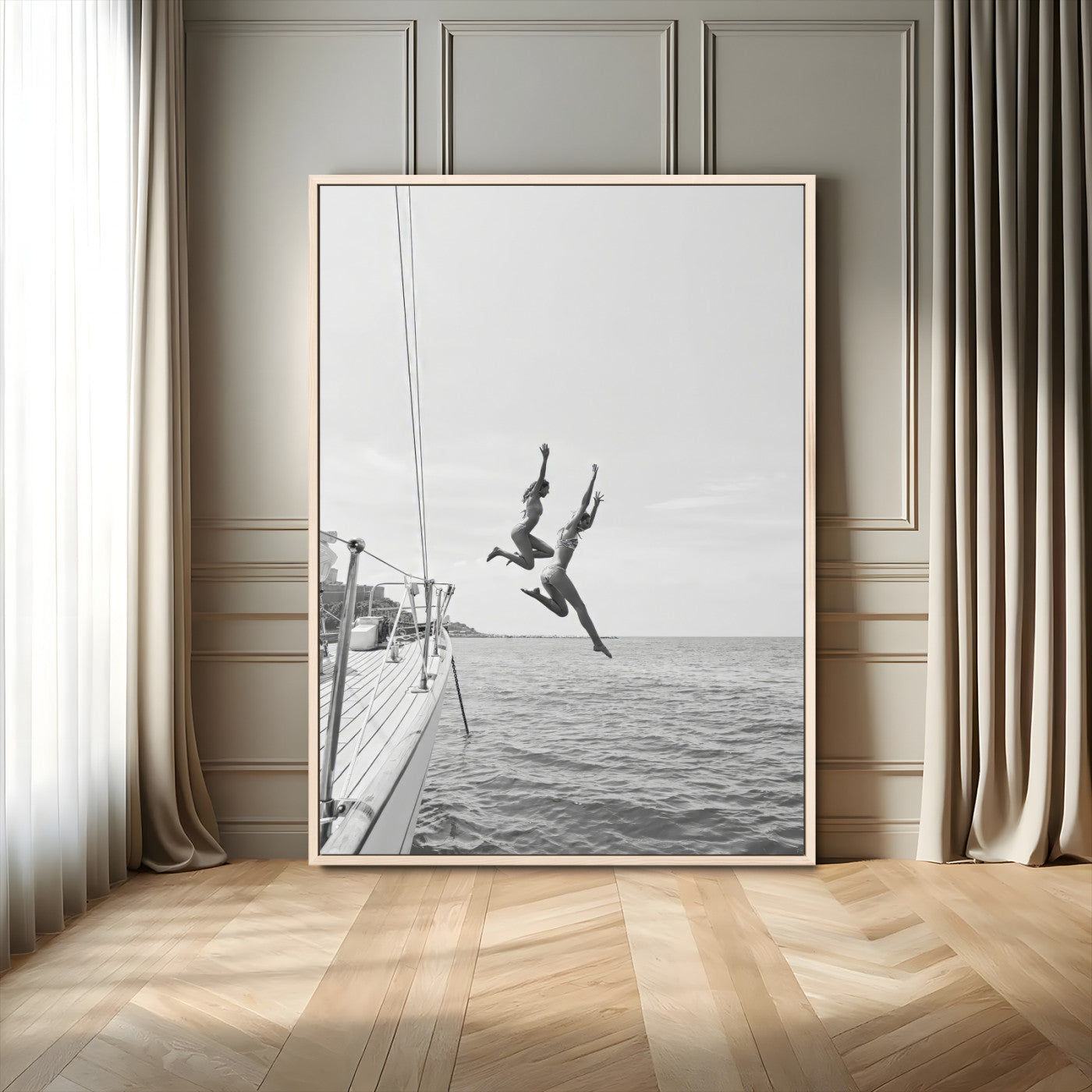 Black and white canvas wall art of two women joyfully jumping off a yacht into the sea, ideal for minimalist coastal or nautical-themed spaces.