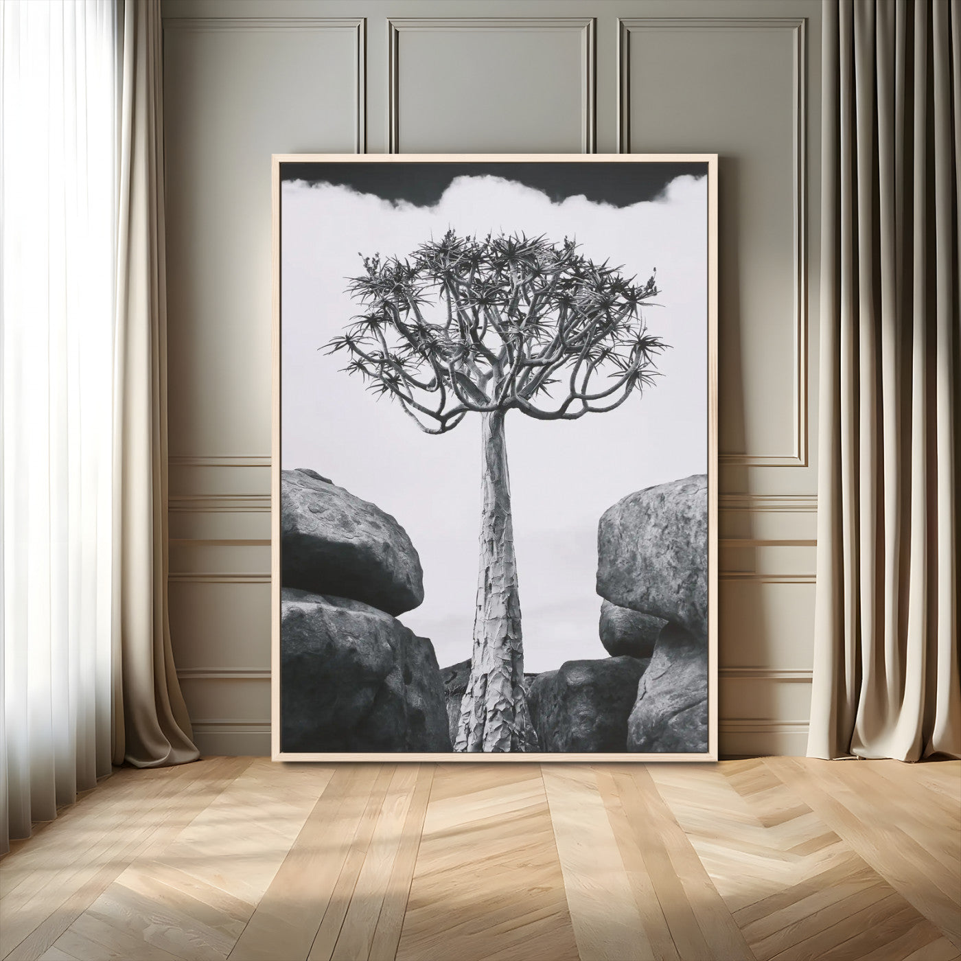 Tall desert tree in black and white, standing between large rocks, perfect for bold and minimalist nature-themed interior spaces.