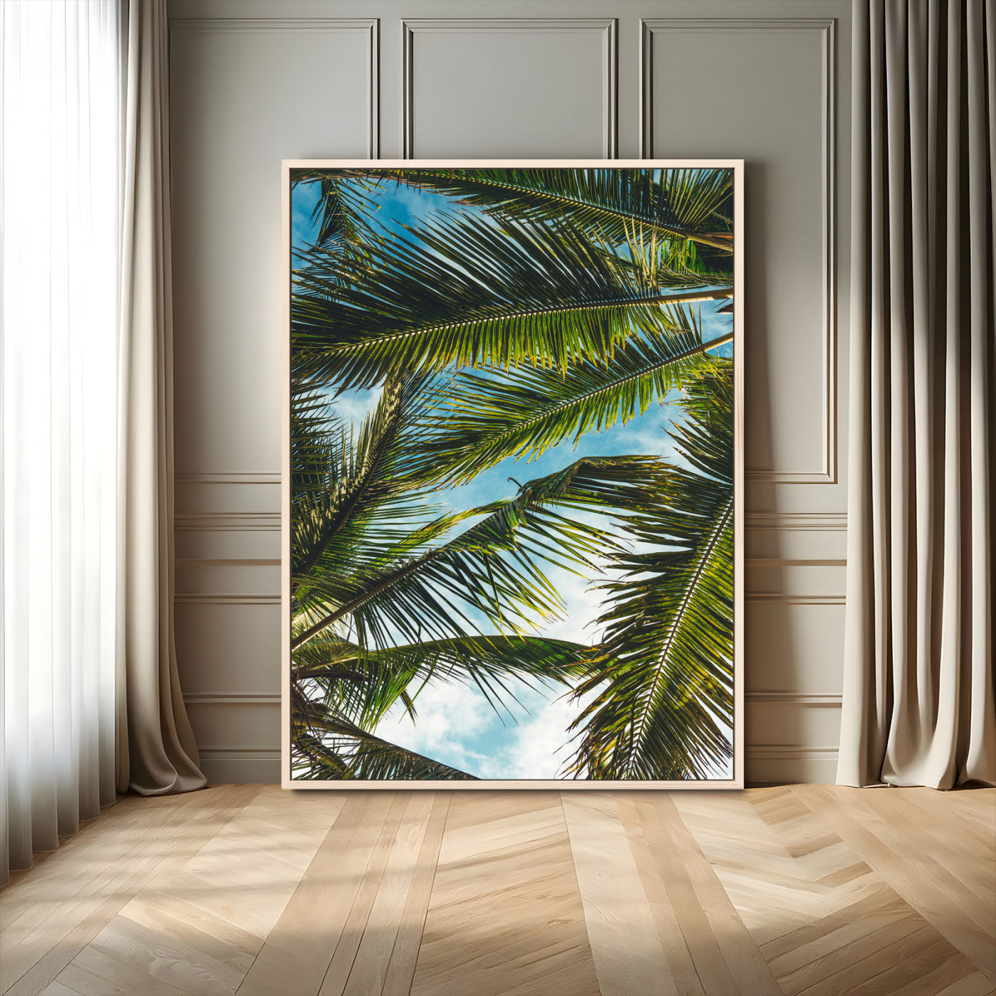 Looking up at lush green palm leaves against a bright blue sky, creating a tropical and relaxing coastal aesthetic.