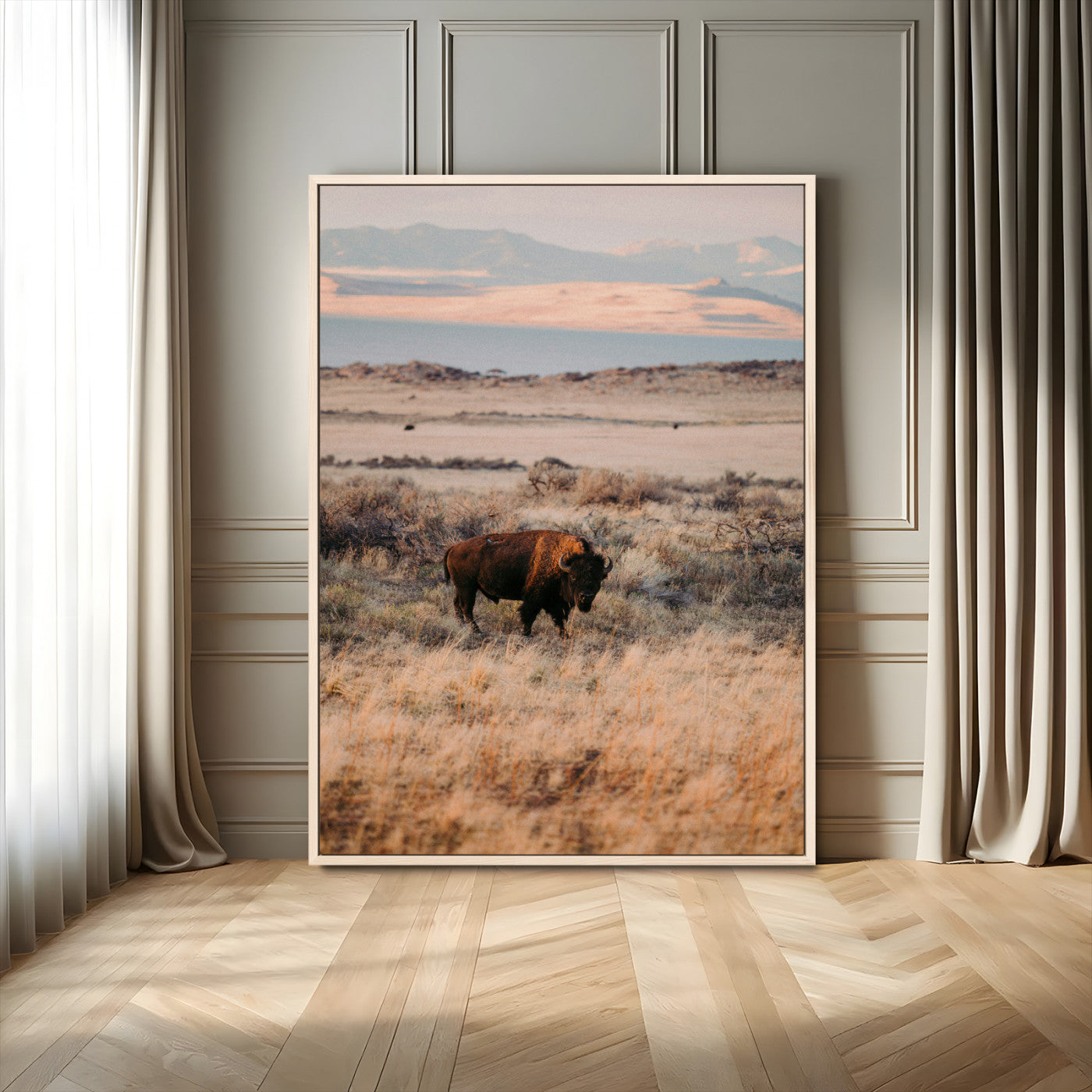 A solitary bison standing in golden prairie grass with distant mountains and soft sunset light, ideal for rustic, lodge, and western decor.