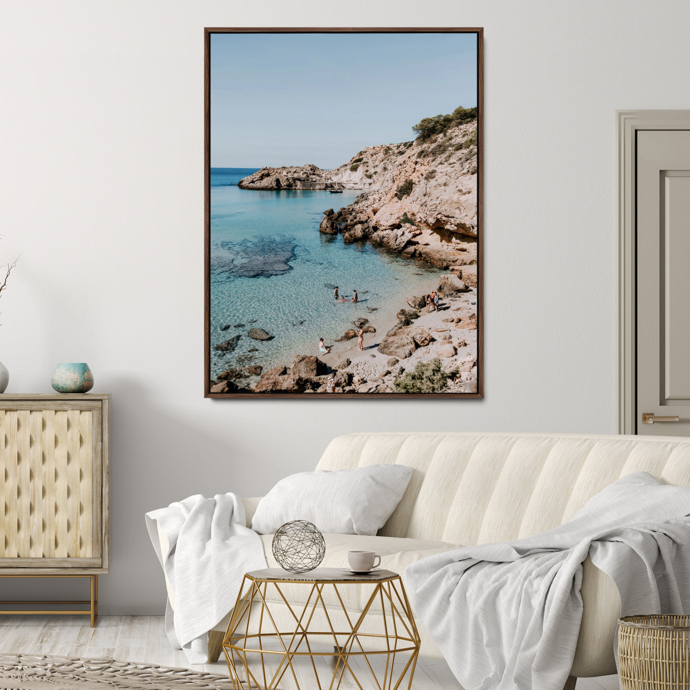 A vibrant coastal photo of a rocky Mediterranean cove with turquoise waters and beachgoers, ideal for boho coastal or summer-inspired interiors.
