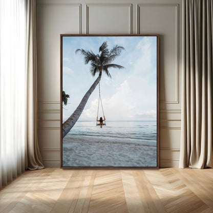 Wall art of a girl on a swing hanging from a palm tree over calm ocean waters, perfect for tropical or minimalist coastal decor.