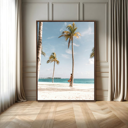 Person leaning on a palm tree at a tropical beach with white sand and turquoise water, perfect for coastal or beach-themed home decor.