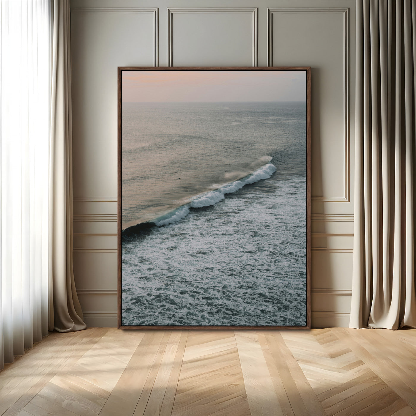 Aerial view of ocean waves rolling towards the shore under a soft sunset sky, creating a peaceful and minimalist coastal scene.