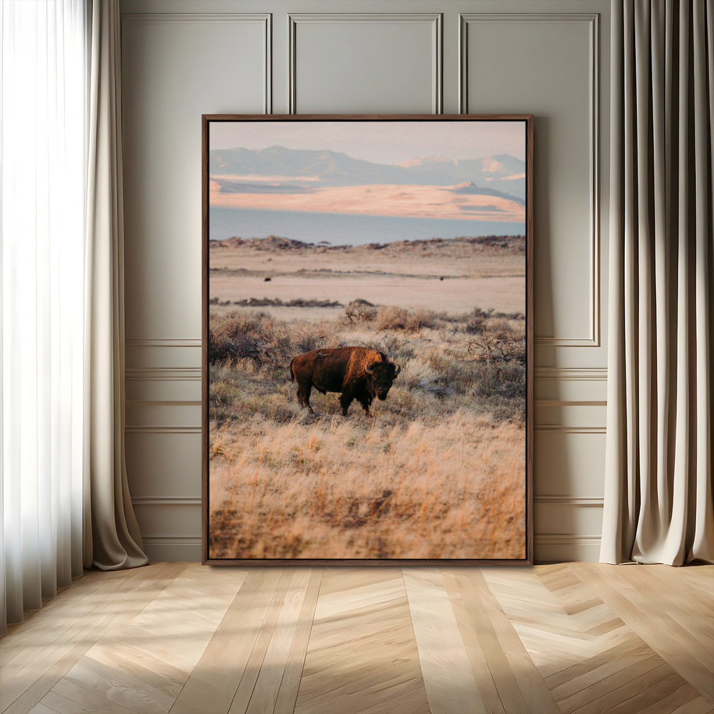 A solitary bison standing in golden prairie grass with distant mountains and soft sunset light, ideal for rustic, lodge, and western decor.