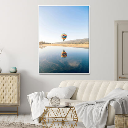 Canvas of a hot air balloon floating above a calm lake with soft reflections and vibrant sky, ideal for modern minimalist or adventure-themed home decor.