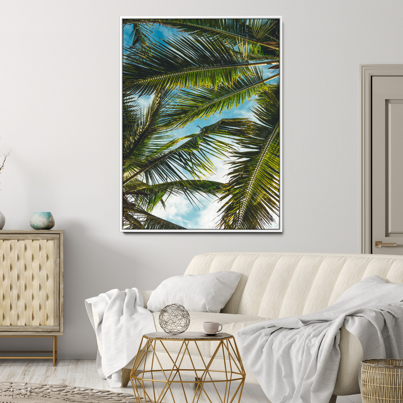 Looking up at lush green palm leaves against a bright blue sky, creating a tropical and relaxing coastal aesthetic.