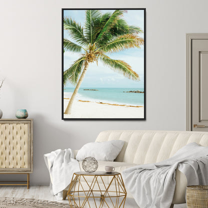 A tall palm tree leaning over a white sandy beach with turquoise ocean waves, creating a peaceful and tropical coastal scene.