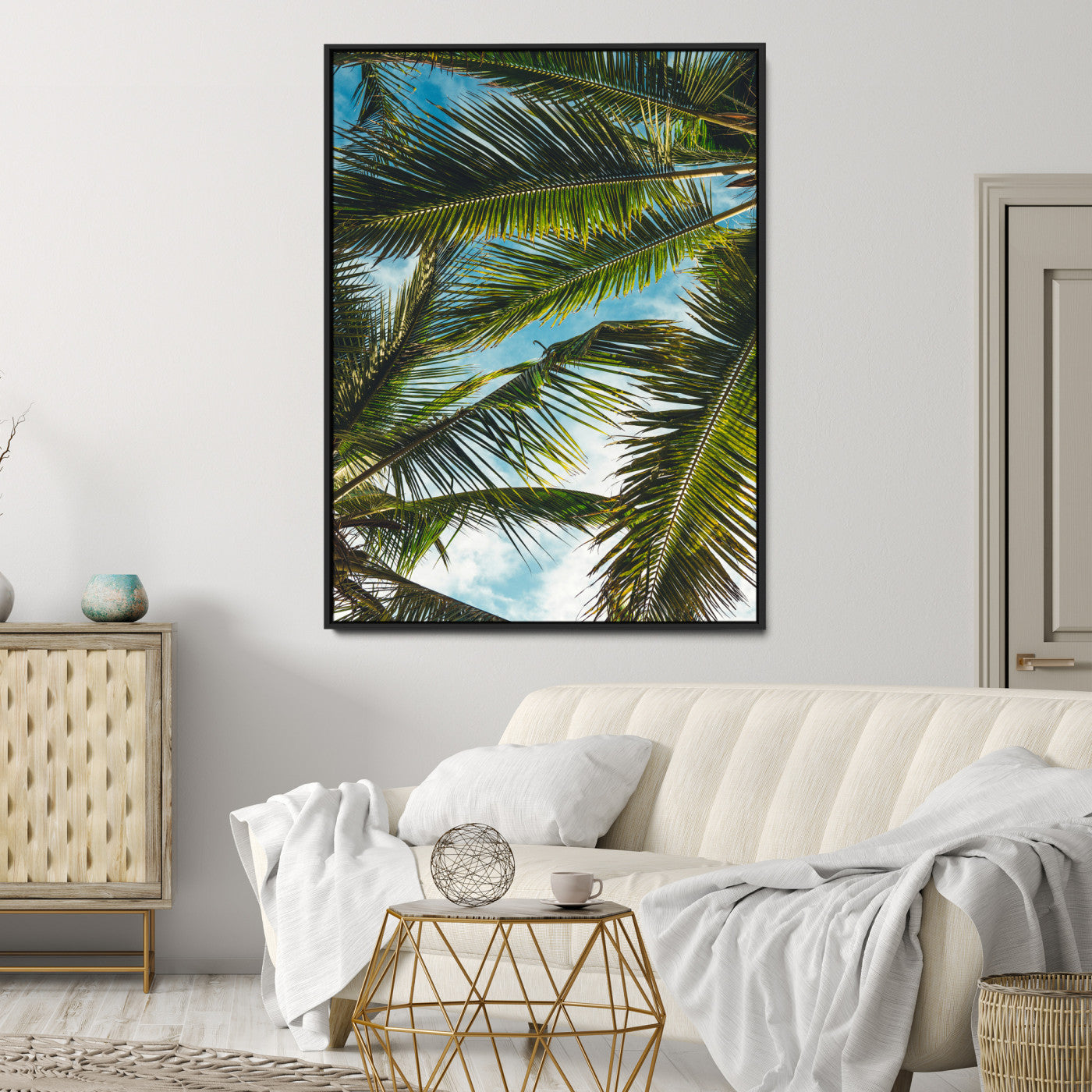 Looking up at lush green palm leaves against a bright blue sky, creating a tropical and relaxing coastal aesthetic.