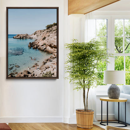 A vibrant coastal photo of a rocky Mediterranean cove with turquoise waters and beachgoers, ideal for boho coastal or summer-inspired interiors.
